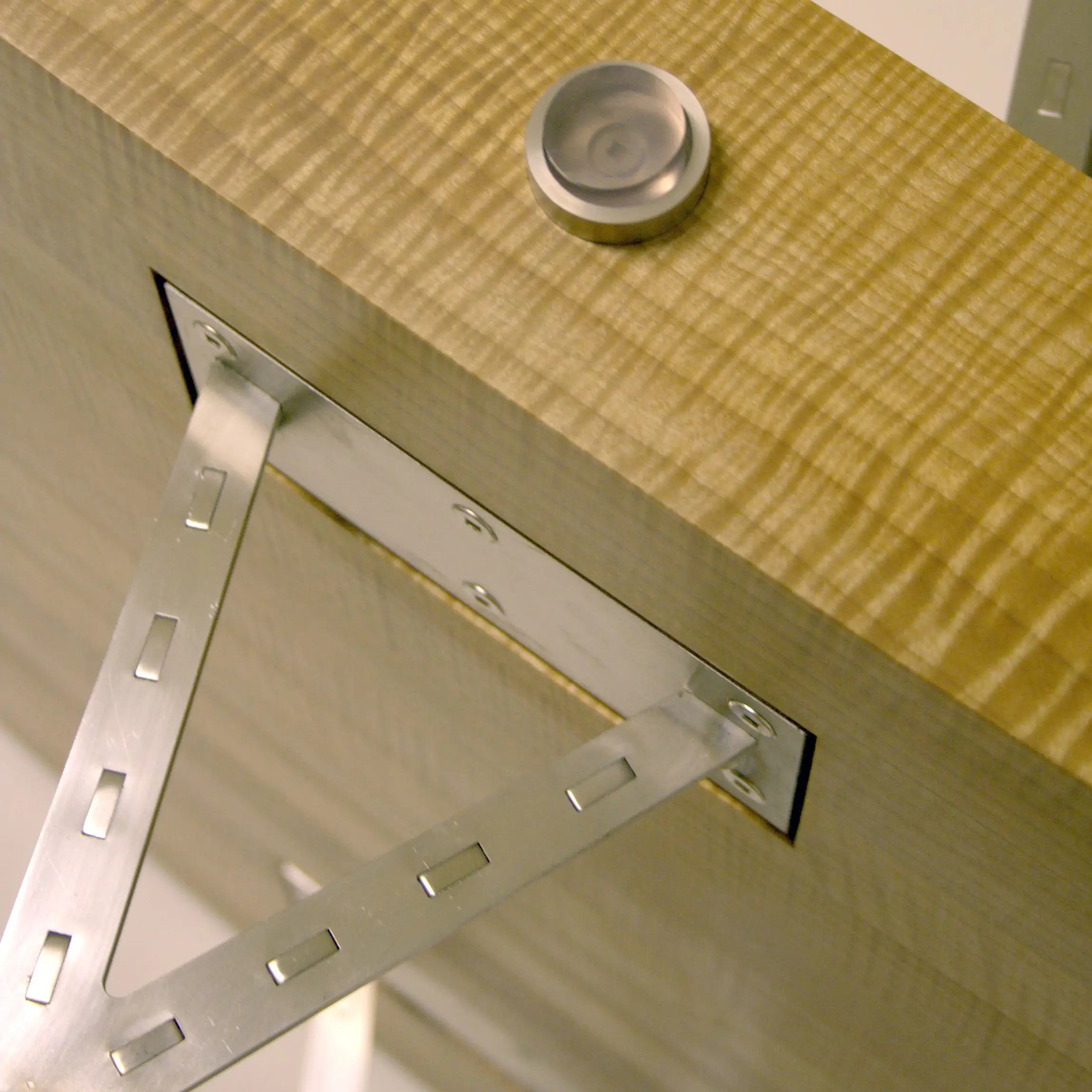 Detail of triangular stainless steel bracket and mounting plate on the Erosion Table