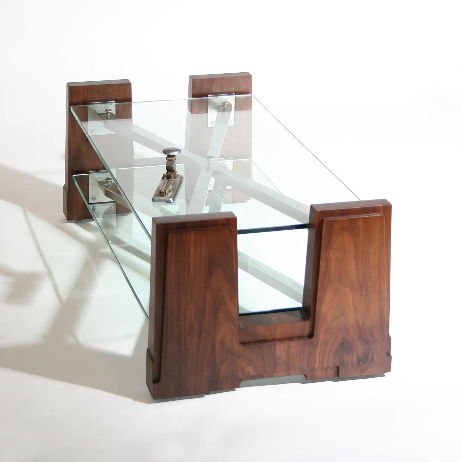 Angled view of the Extension Table showing its sculptural composition of glass, wood, and steel.