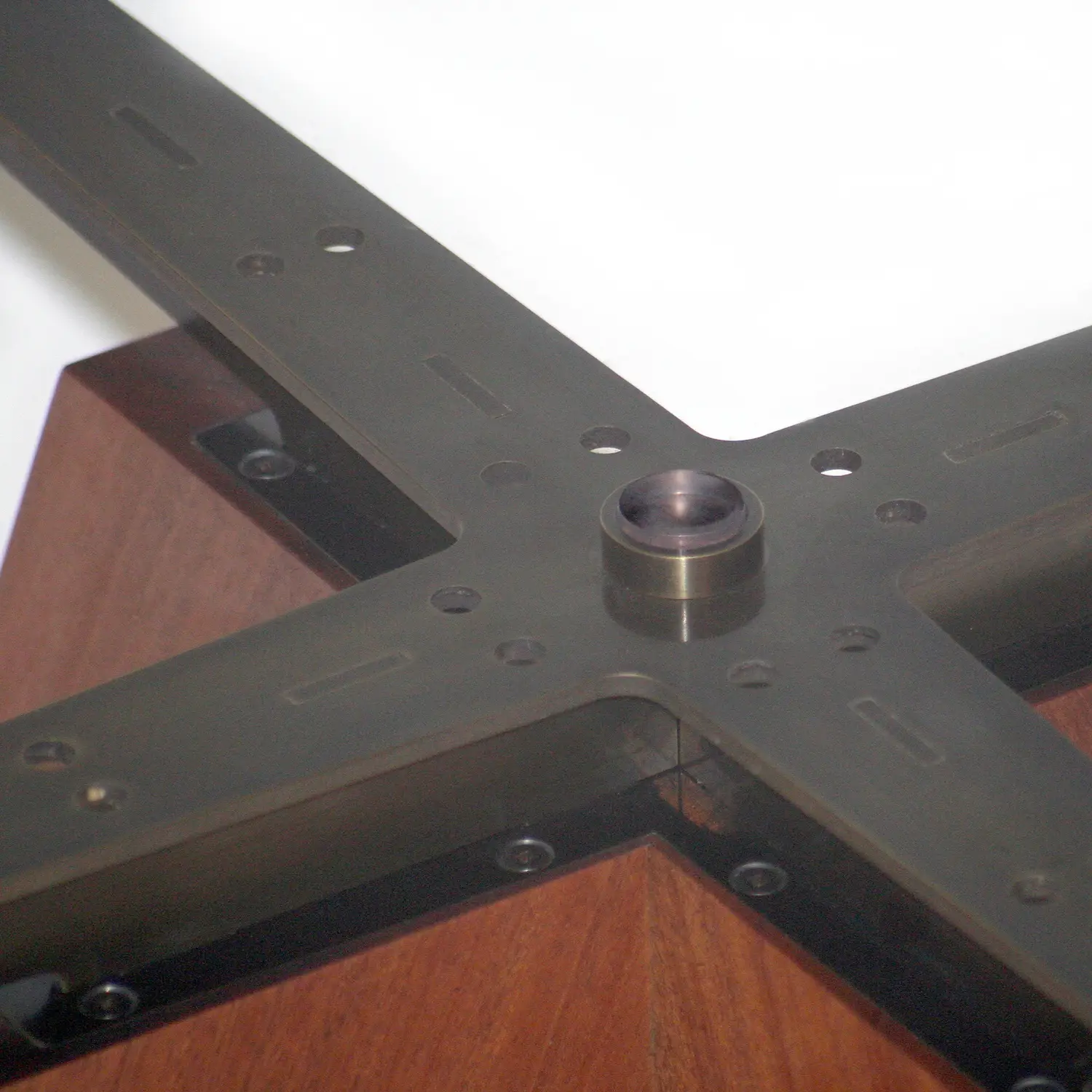Angled view of the Float Table showing the relationship between its circular glass surface and geometric base.