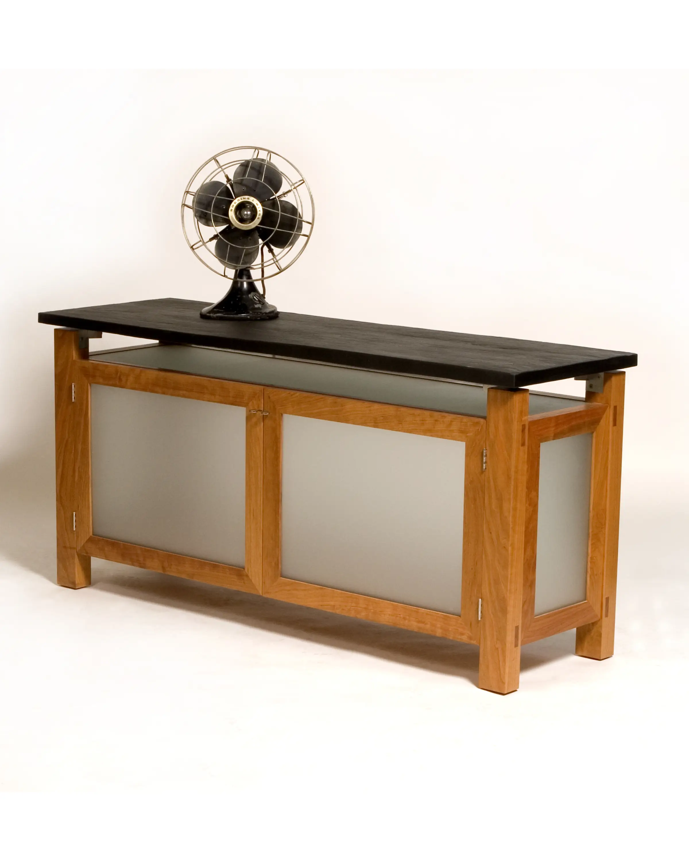 Petrone Console shown at an angle with a slate top and framed cabinet panels