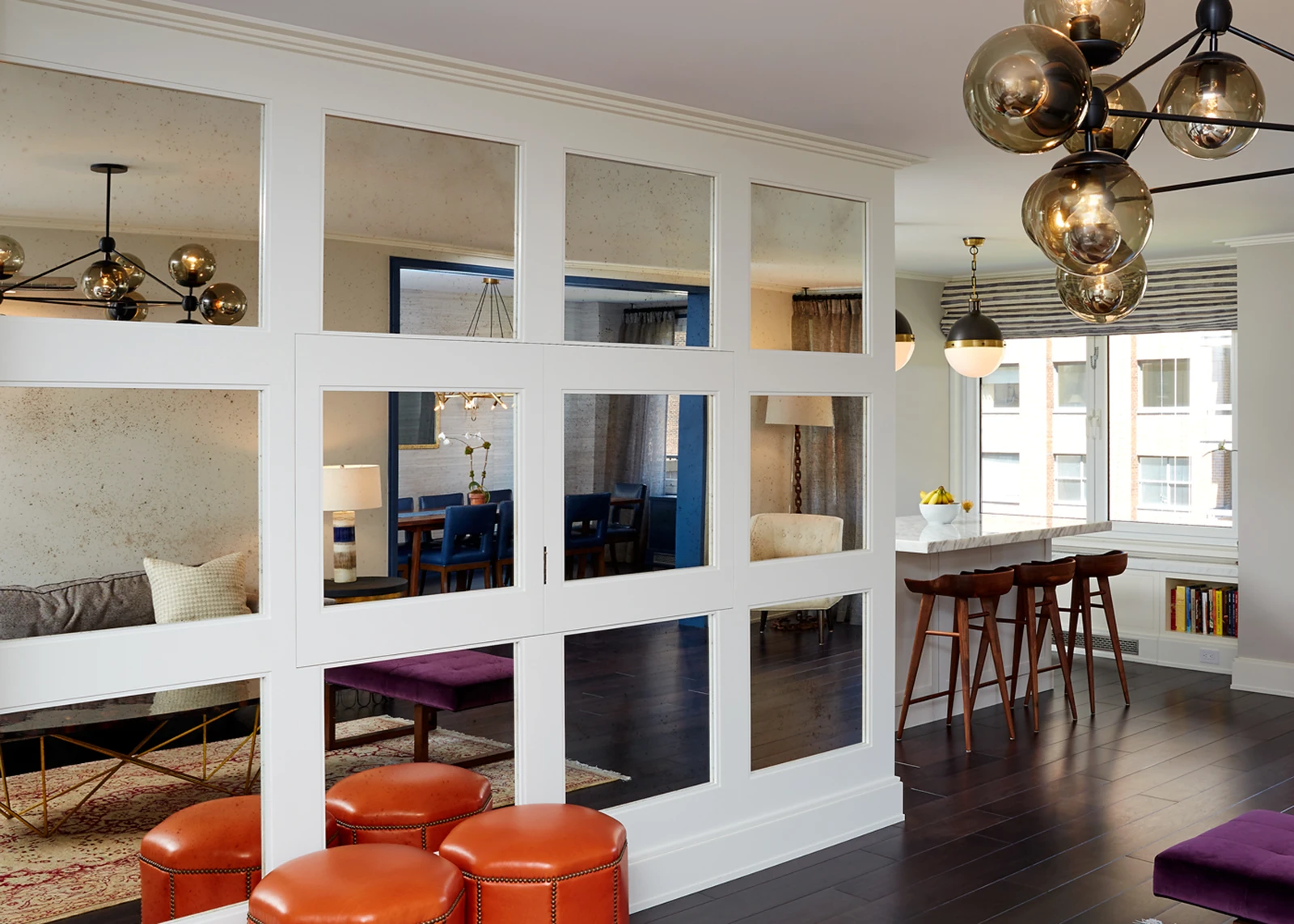 Upper East Side apartment interior featuring a custom glazed partition, dark wood flooring, contemporary lighting, and an open kitchen